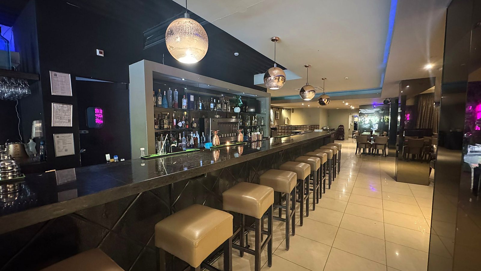The bar, stools and backlit bottles