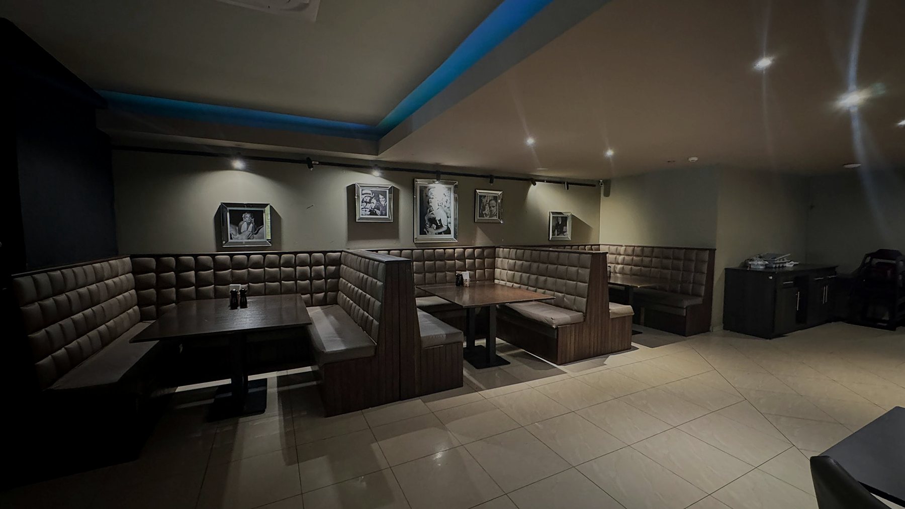 Quilted leather booths under blue cove lighting