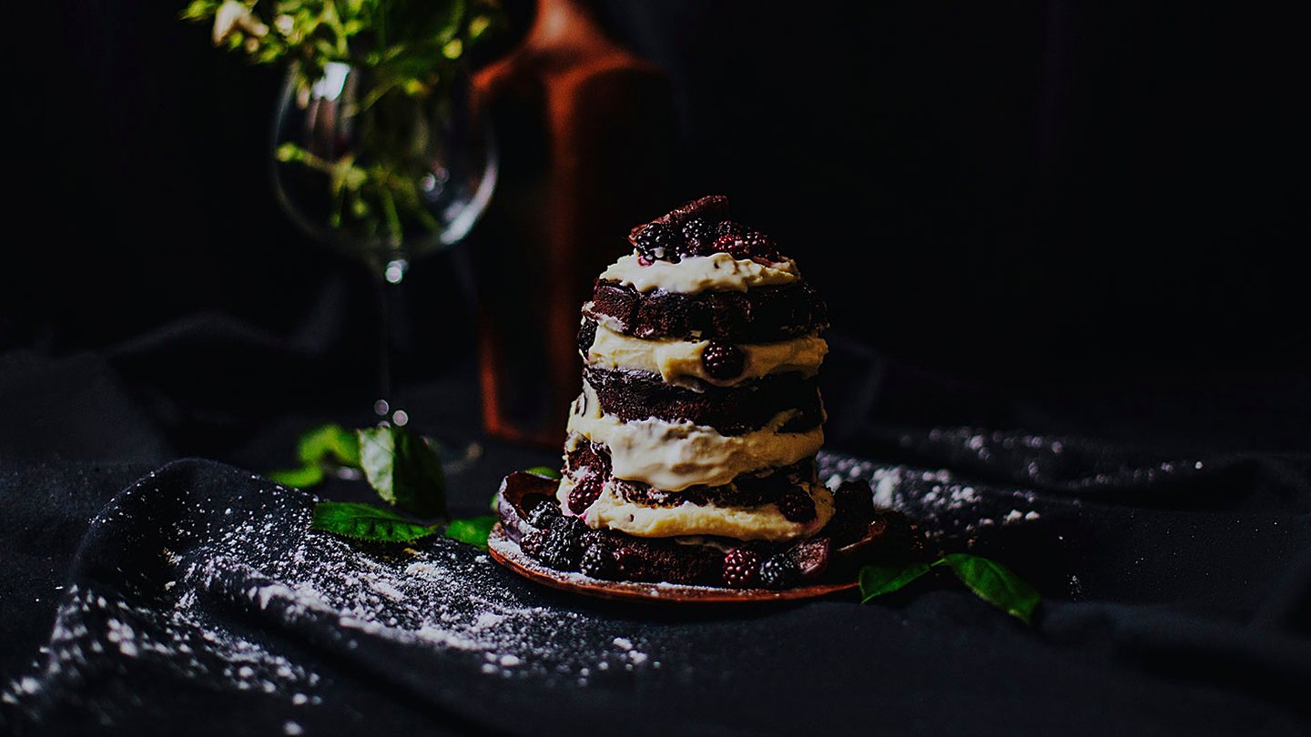 Dessert and a glass of red wine on a dark table