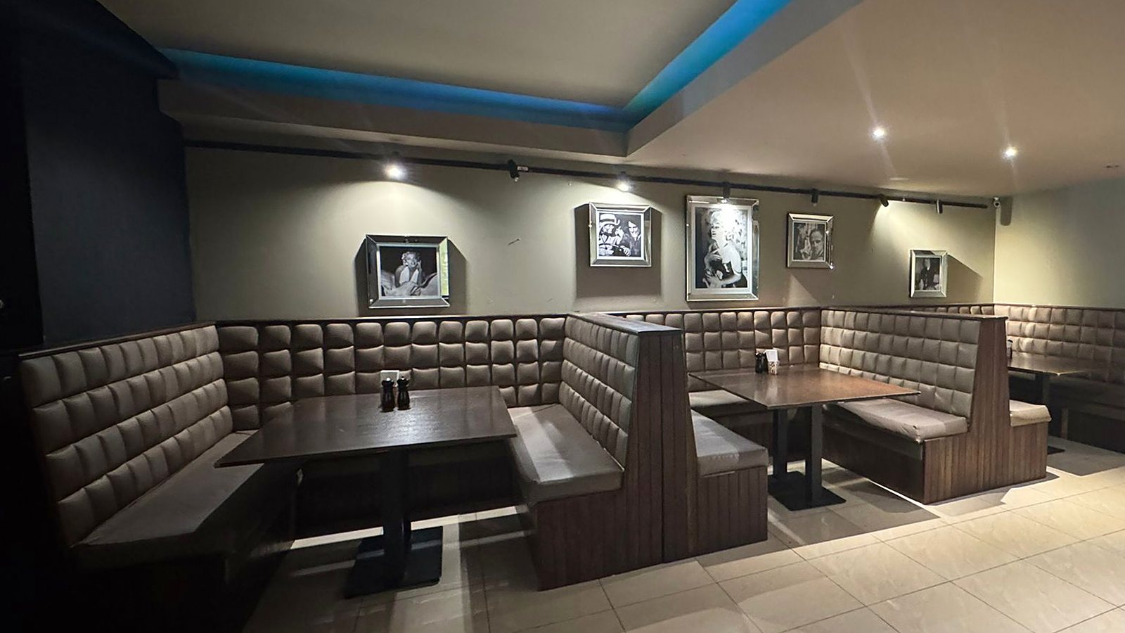 Quilted leather booths under blue cove lighting